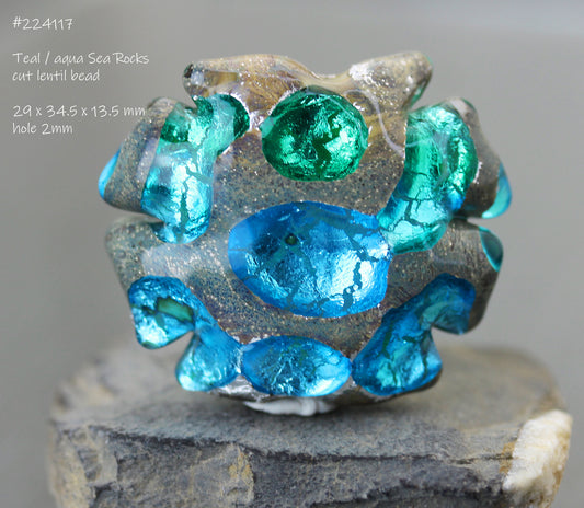 Aqua blue and teal green lampwork glass focal bead shaped like a cut lentil, to resemble rocks with tidepools.
