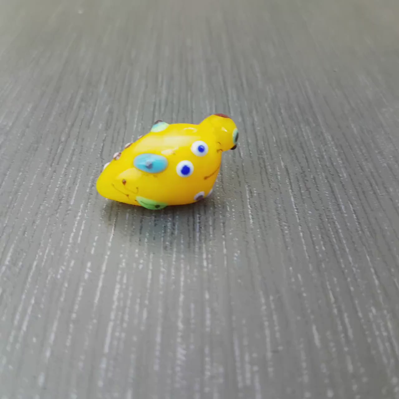 Mini oiseau en verre jaune motif Miro. Perle bleue brillante pour pendentif ou centre de collier. Fait main  Anne Londez SRA